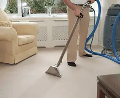 Carpet cleaning professional removing dirt and stains with a hot-water extraction tool in a home, Columbia, MO.
